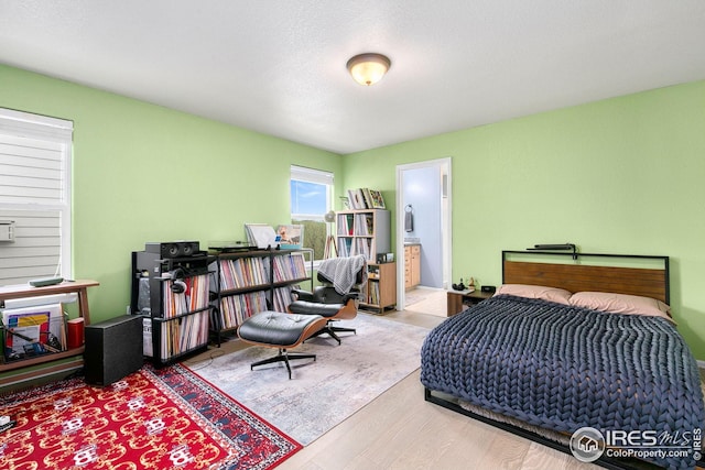 bedroom with wood finished floors and ensuite bath
