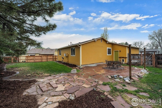 rear view of house with a lawn, a patio, and a fenced backyard