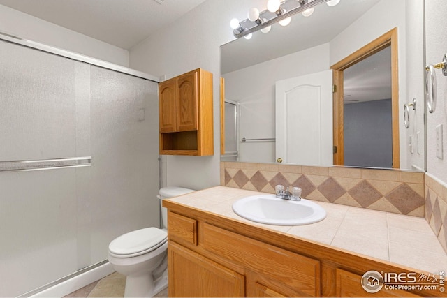 full bath featuring tile patterned floors, vanity, toilet, and a stall shower