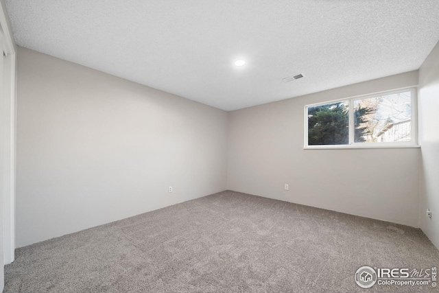 unfurnished room with recessed lighting, visible vents, and carpet