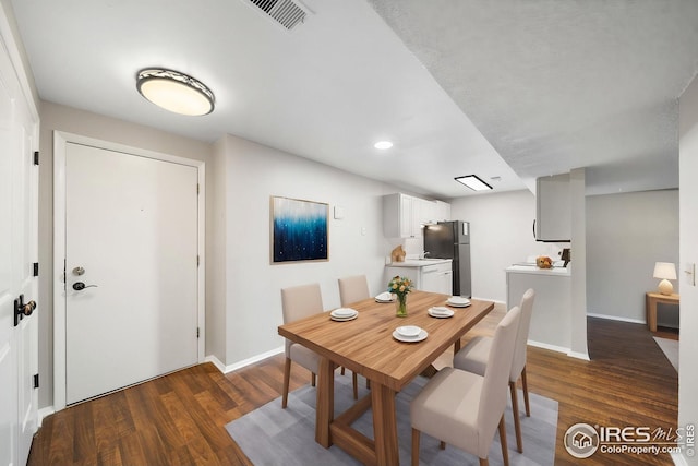dining area featuring visible vents, dark wood-style floors, and baseboards