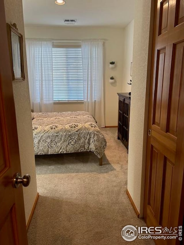 bedroom with recessed lighting, visible vents, light colored carpet, and baseboards
