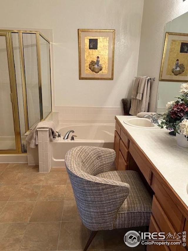 bathroom featuring a garden tub, double vanity, a sink, and a shower stall