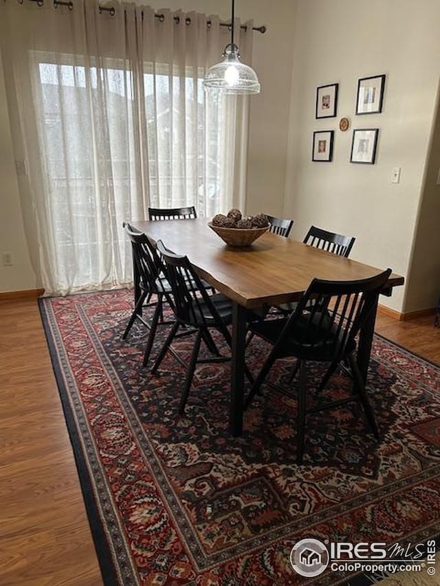 dining area featuring baseboards, wood finished floors, and plenty of natural light