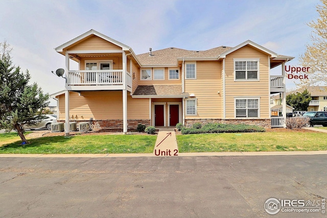 3740 Ponderosa Ct Unit 2, Evans, CO 80620 - view of property with a front lawn, a balcony, and stone siding