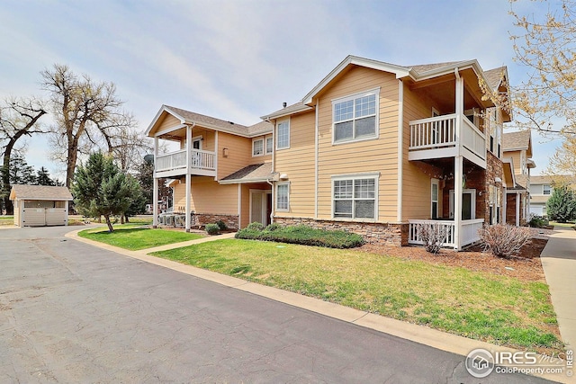 3740 Ponderosa Ct Unit 2, Evans, CO 80620 - view of front of home featuring a front yard, a balcony, and stone siding