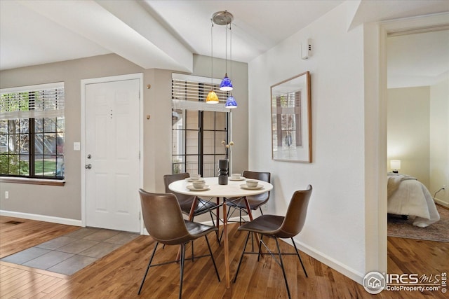 dining area with baseboards, visible vents, and wood finished floors