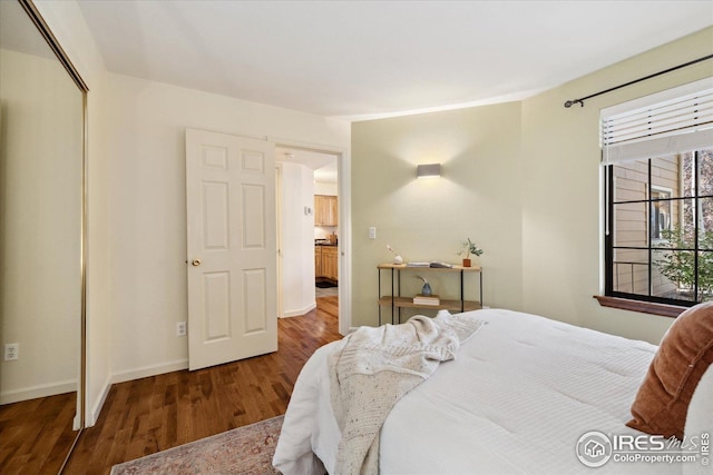 bedroom with a closet, baseboards, and wood finished floors