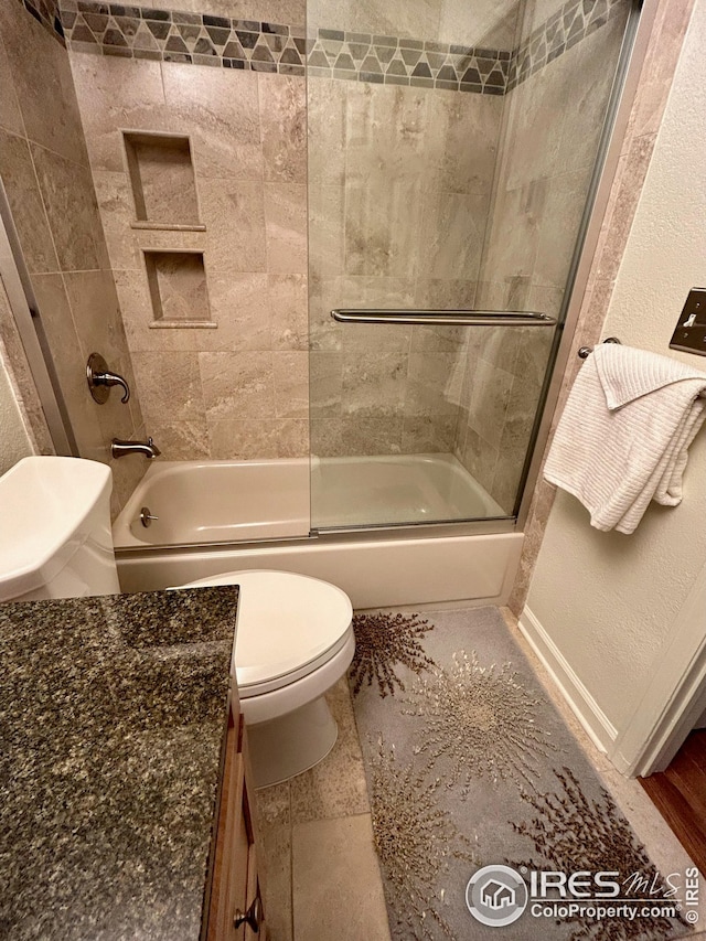 full bathroom with toilet, bath / shower combo with glass door, and vanity