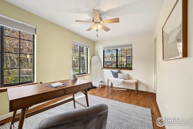 home office featuring baseboards, a ceiling fan, and wood finished floors