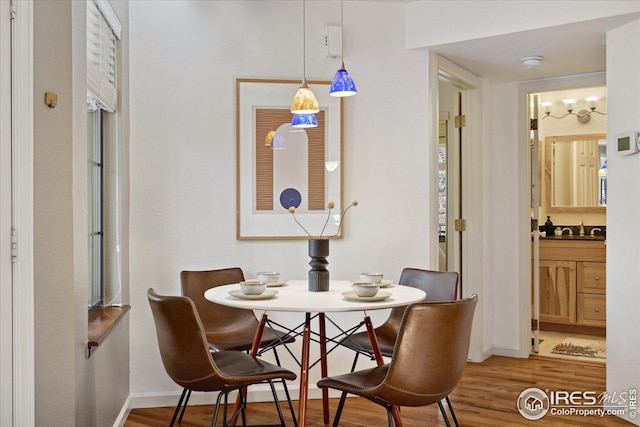 dining space with baseboards and wood finished floors