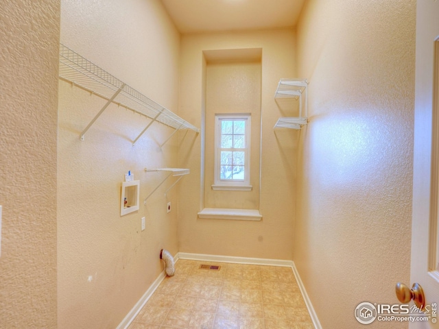 clothes washing area with hookup for a washing machine, laundry area, hookup for an electric dryer, baseboards, and visible vents