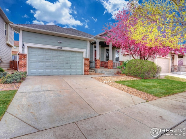 view of front of house featuring concrete driveway, a porch, brick siding, and a garage