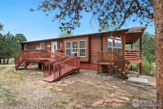 back of property with stairs and a wooden deck