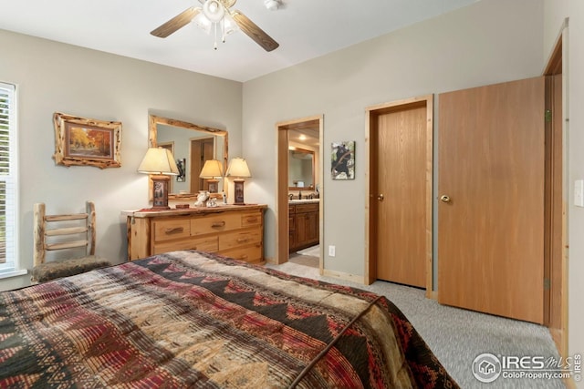 bedroom with a ceiling fan, light carpet, and ensuite bath