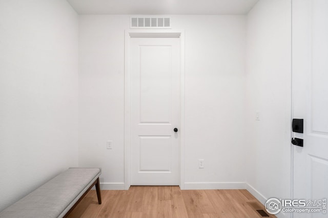 interior space featuring visible vents, light wood-style flooring, and baseboards