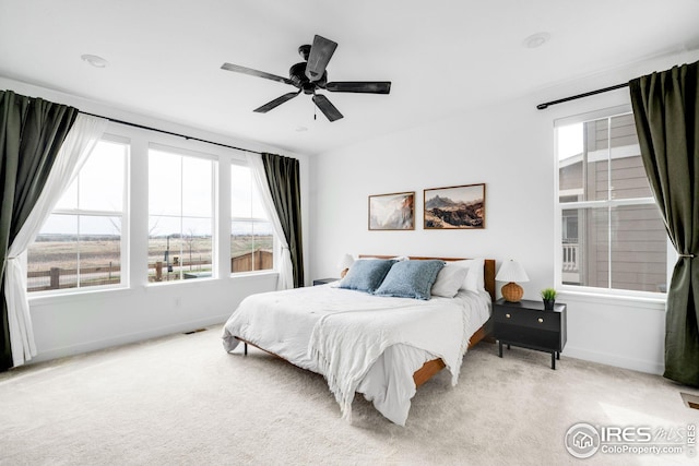 bedroom with baseboards, visible vents, ceiling fan, and carpet