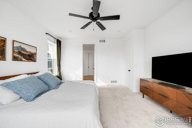 bedroom featuring visible vents, ceiling fan, light colored carpet, and baseboards