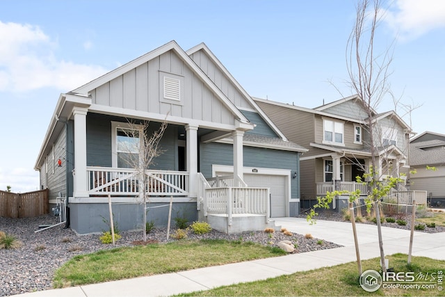 view of front of property featuring covered porch, board and batten siding, driveway, and a garage