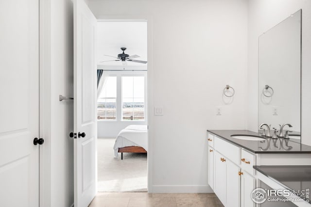 bathroom with ceiling fan, ensuite bathroom, baseboards, vanity, and tile patterned flooring