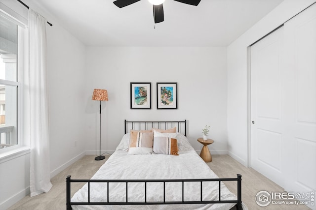 bedroom featuring baseboards, a ceiling fan, and light carpet