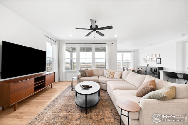 living room featuring a ceiling fan, light wood finished floors, and recessed lighting