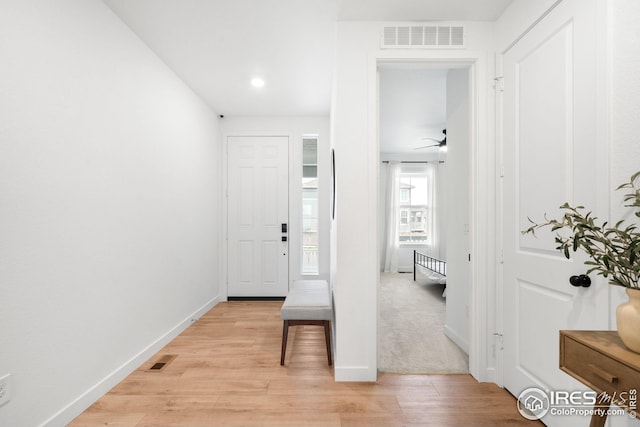 hallway with recessed lighting, visible vents, baseboards, and light wood-style floors
