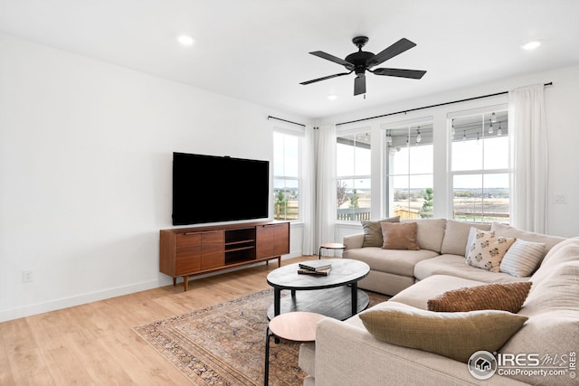 living room featuring light wood-style floors, ceiling fan, recessed lighting, and baseboards