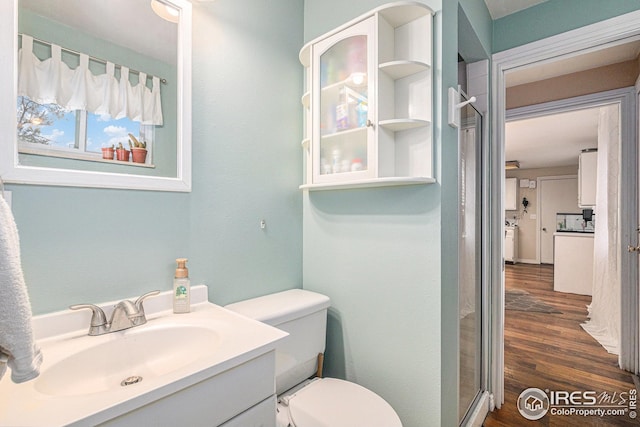 bathroom with wood finished floors, toilet, and vanity