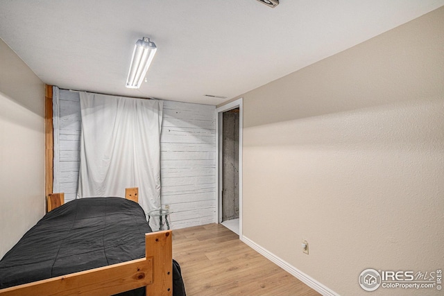 bedroom featuring wood finished floors and baseboards