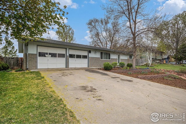 single story home featuring aphalt driveway, fence, brick siding, a front lawn, and a garage