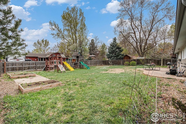 view of yard featuring a patio area, a fenced backyard, a garden, and a playground