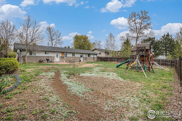 exterior space with a playground, a yard, and a fenced backyard