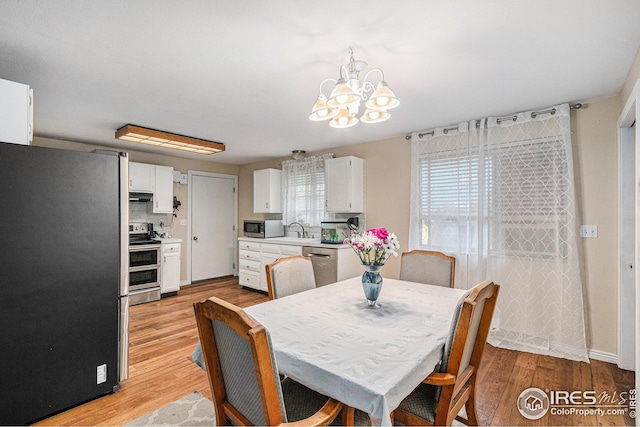 dining area with a chandelier and light wood-style floors