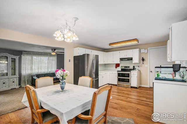 dining room featuring light wood-type flooring and ceiling fan with notable chandelier