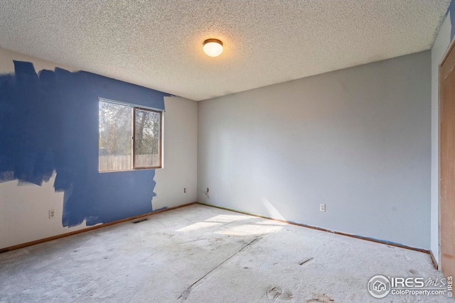 unfurnished room featuring baseboards, visible vents, carpet floors, and a textured ceiling