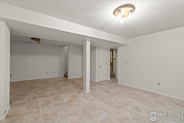 finished basement with baseboards and a textured ceiling