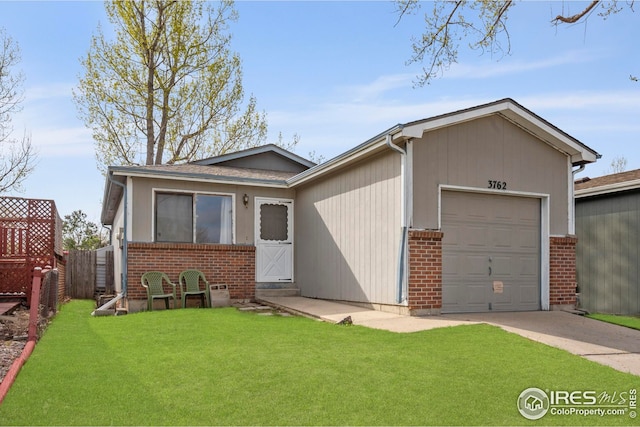 view of front facade featuring a front lawn, fence, a garage, and brick siding