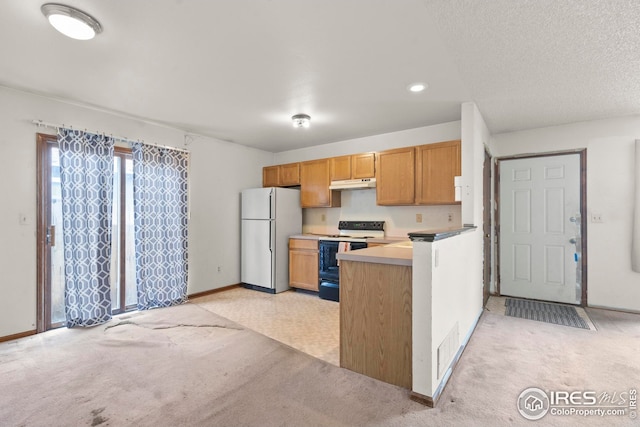 kitchen featuring light colored carpet, freestanding refrigerator, range with electric stovetop, under cabinet range hood, and baseboards