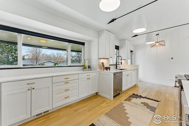 kitchen featuring light wood-style flooring, decorative backsplash, appliances with stainless steel finishes, a sink, and visible vents