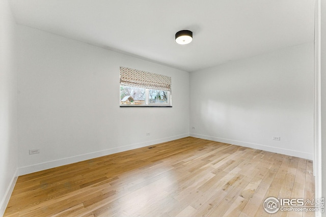 unfurnished room featuring light wood-style flooring and baseboards