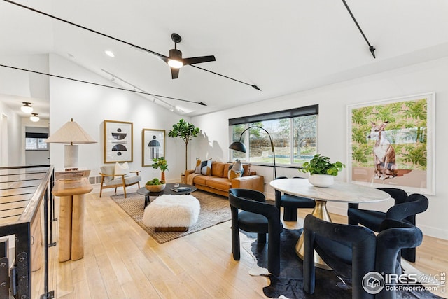 interior space featuring light wood finished floors, rail lighting, a wealth of natural light, and lofted ceiling