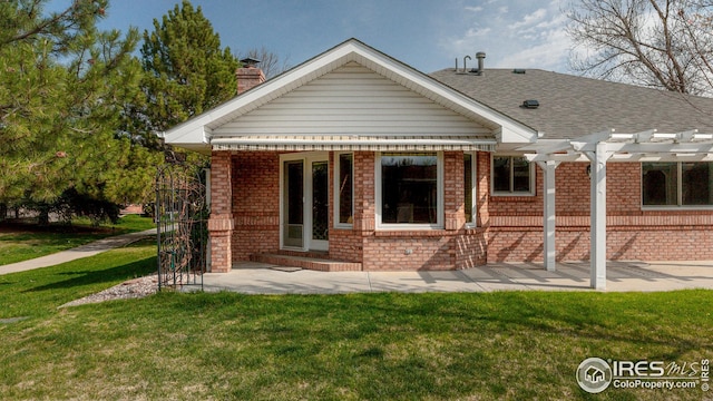 back of property with a chimney, brick siding, a yard, and a pergola