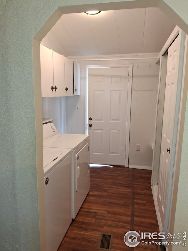 laundry room with independent washer and dryer, a textured wall, visible vents, cabinet space, and dark wood-type flooring