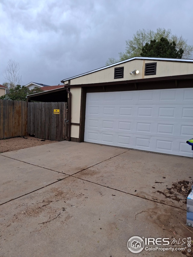 garage featuring fence and driveway