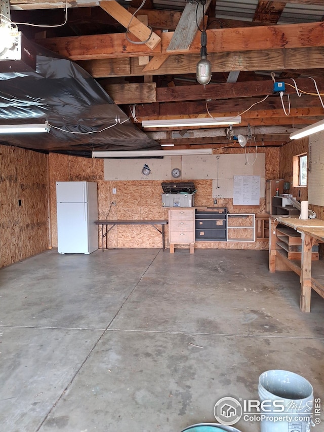 garage with a workshop area and freestanding refrigerator