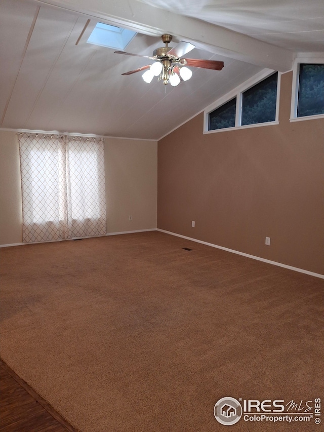 interior space featuring ceiling fan, vaulted ceiling with beams, and baseboards