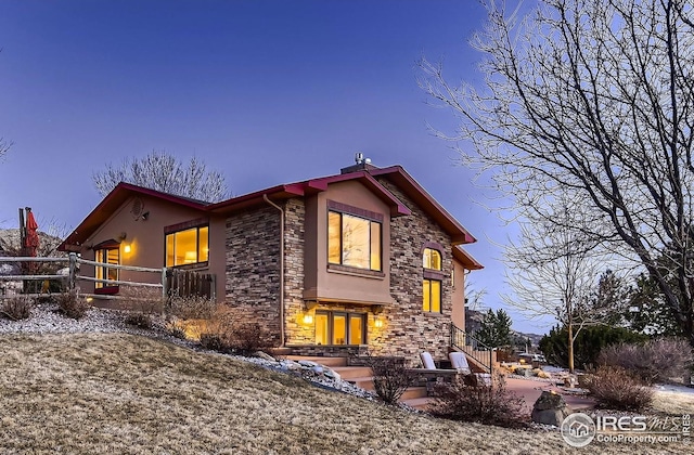 view of front of property featuring stucco siding and stone siding
