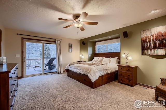 bedroom with baseboards, access to outside, a textured ceiling, and light colored carpet