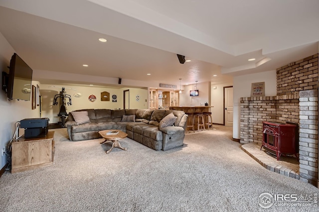 living room with a wood stove, baseboards, recessed lighting, bar, and carpet flooring